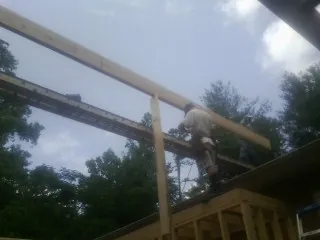 Carpenter setting a ridge beam over a new addition frame — Ice Dam Removal by Roofing Brothers in Greenbelt