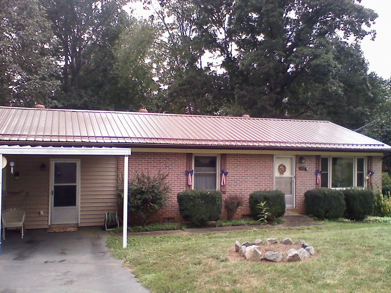 Bronze metal roof and carport on a brick ranch home — Roof Repair work by our crew in Greenbelt